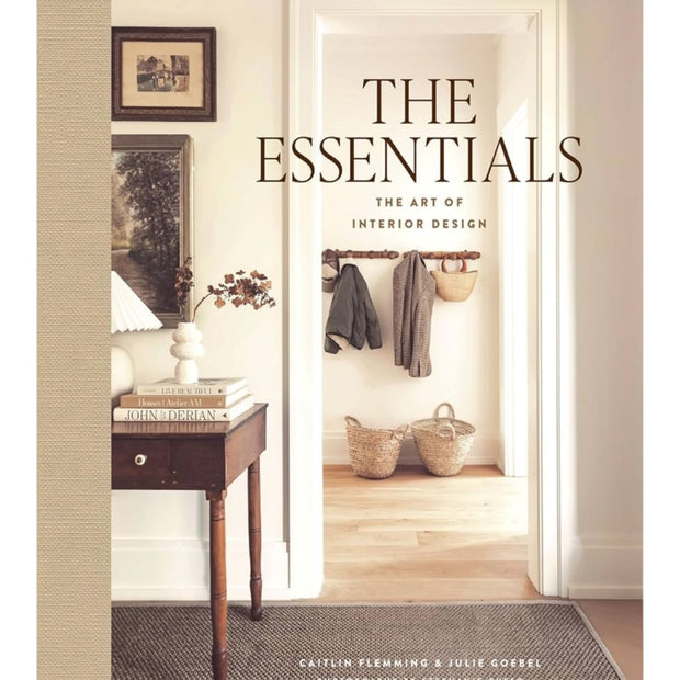 Open interior design book titled "The Essentials: The Art of Interior Design" by Abrams & Chronicle Books showing colorful pages.