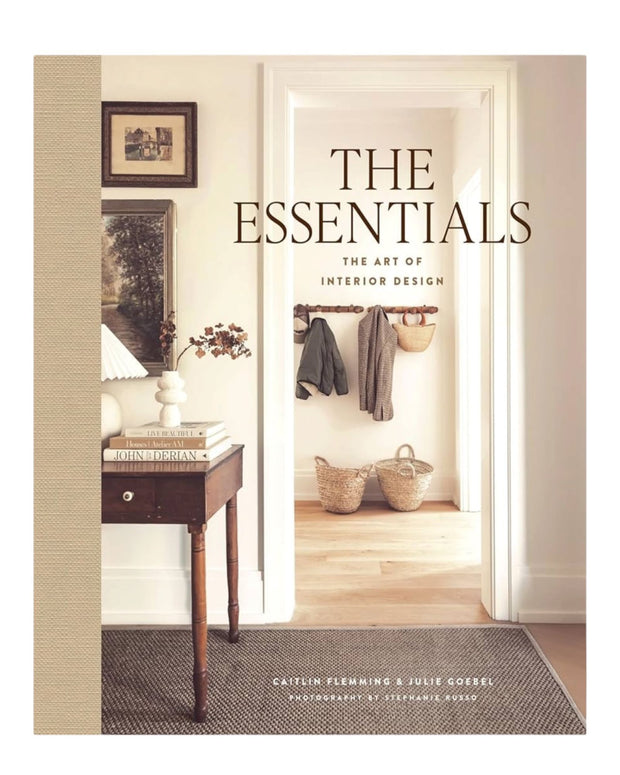 Open interior design book titled "The Essentials: The Art of Interior Design" by Abrams & Chronicle Books showing colorful pages.