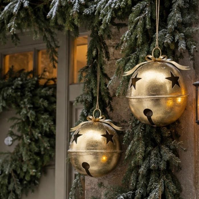 Gold Metal Hanging Bell With Cut Out Stars, two gold bells hanging in an evergreen porch display