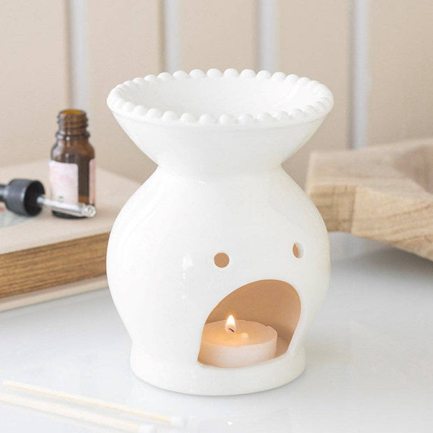 White Ceramic Beaded Rim Oil Burner, white beaded-rim oil burner with a lit tealight