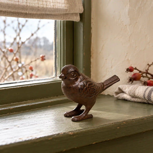 Rust Metal Iron Bird ornament on an olive green cottage windowsill