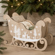 Beige Wooden Decorated Sleigh, beige wooden sleigh with white festive pattern beneath a Christmas tree