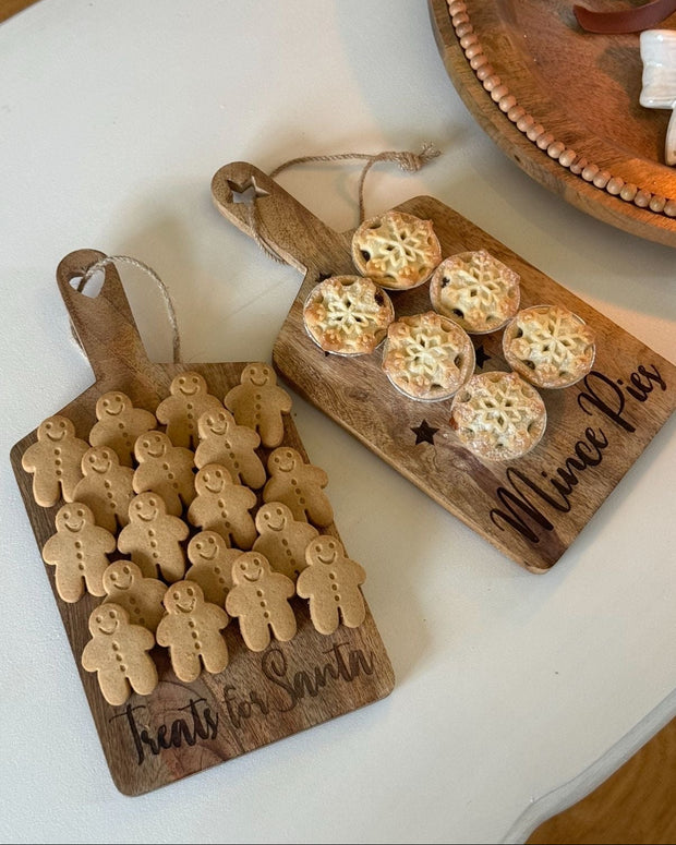 Two wooden cutting boards with baked goods on a white surface