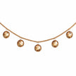 Section of the sleigh bell garland with gold bells and natural cord against white.