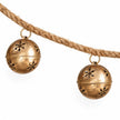 Detail of two gold sleigh bells suspended from the garland's twisted natural cord.