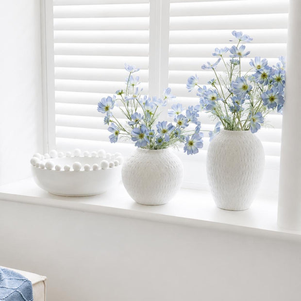 Ashen White Matt Tall Vase, two textured white vases with blue flowers on a windowsill