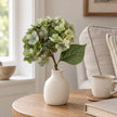 Artificial Short Sage Green Hydrangea Stem, sage green hydrangea in a cream vase beside a mug