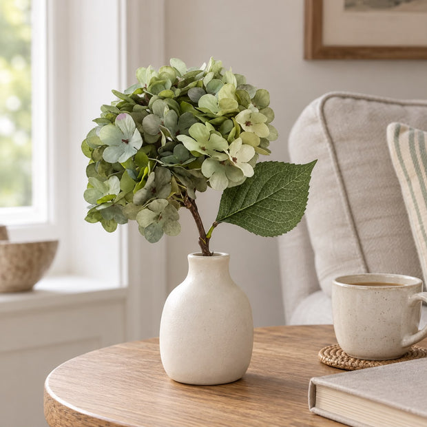 Artificial Short Sage Green Hydrangea Stem, sage green hydrangea in a cream vase beside a mug