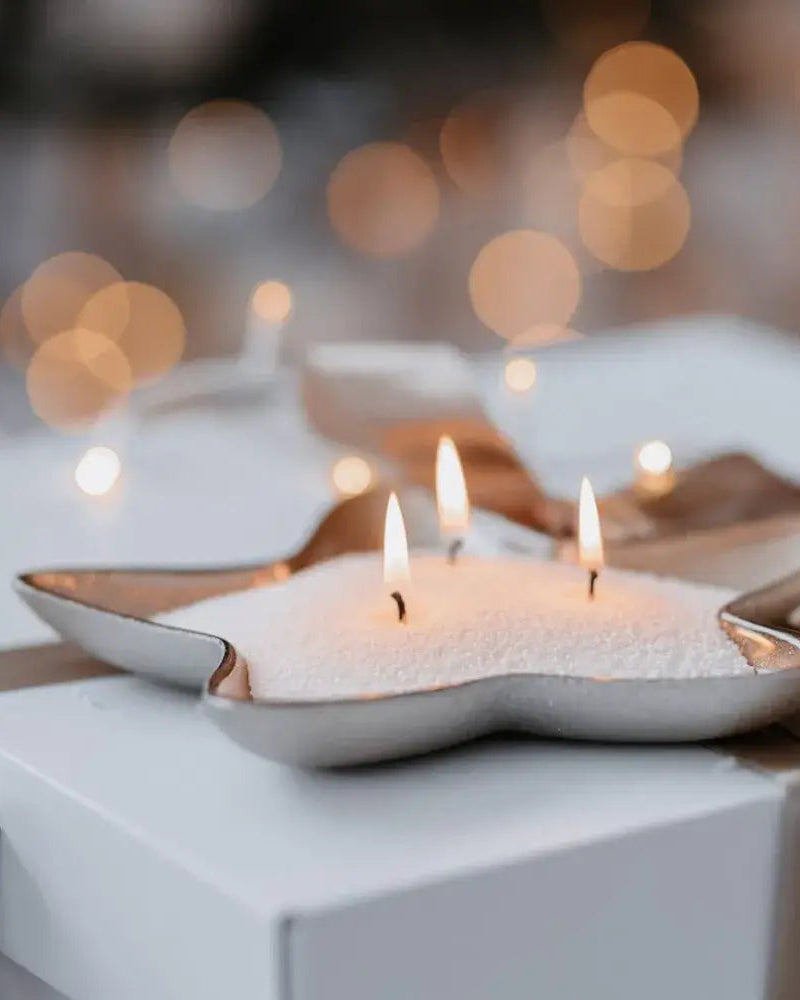 Decorative candles in metallic holders on a blurred background