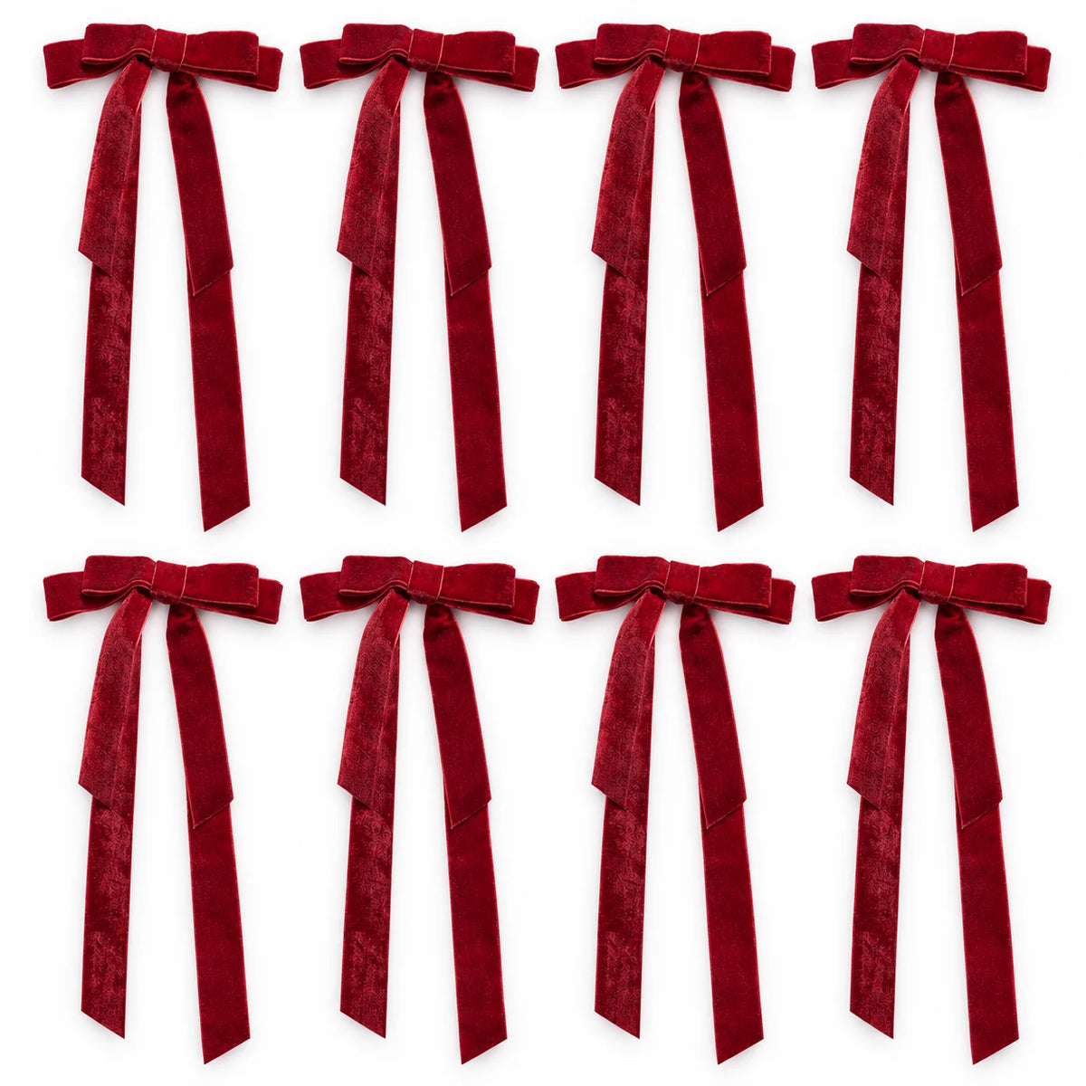 Set of eight burgundy long-tail velvet bows arranged in two rows on white.