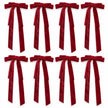 Set of eight burgundy long-tail velvet bows arranged in two rows on white.