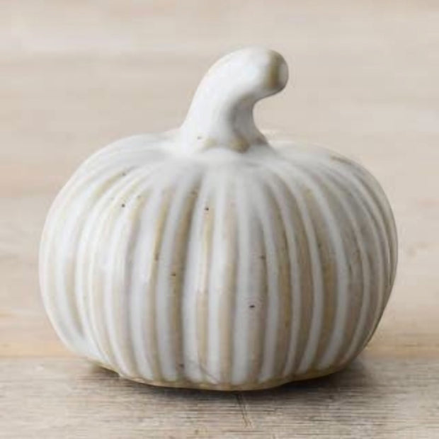 Neutral Reactive Glazed Pumpkin Ornament, cream ribbed pumpkin with a curled stalk on wood