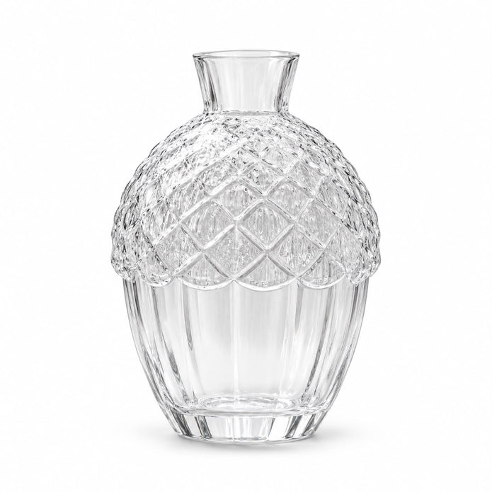 Glass acorn vase with a white flower on a mantel