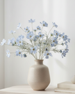Artificial ocean blue cosmos flower stem from Starlight Express, detailed faux plant with vibrant blue petals and green foliage.