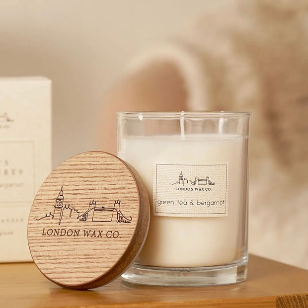 London Wax Company Lidded Candle - Green Tea & Bergamot, clear candle jar beside its engraved wooden lid