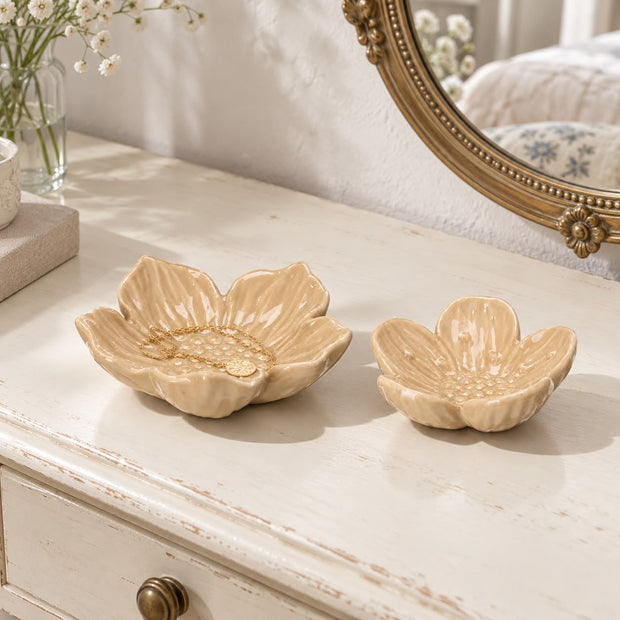 Two beige flower dishes on a cream dresser