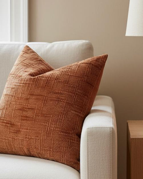 Orange Chenille Cushion Cover, close view of the orange textured cushion on a cream chair