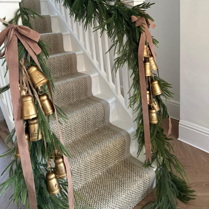 Gold Metal Jingle Bells Garland, two gold bell garlands decorating a staircase