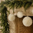 Cream Fluffy Hanging Fur Snowball, cream fluffy snowballs hanging beneath a festive mantel
