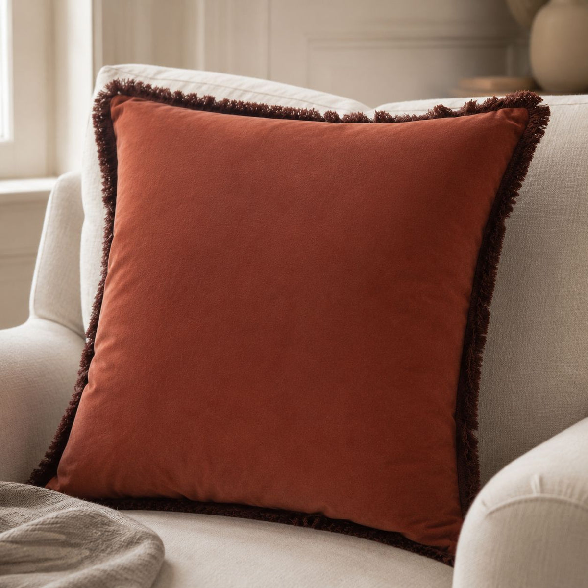 Burgundy Frayed Edge Cushion Cover, close view of burgundy cushion on a cream armchair