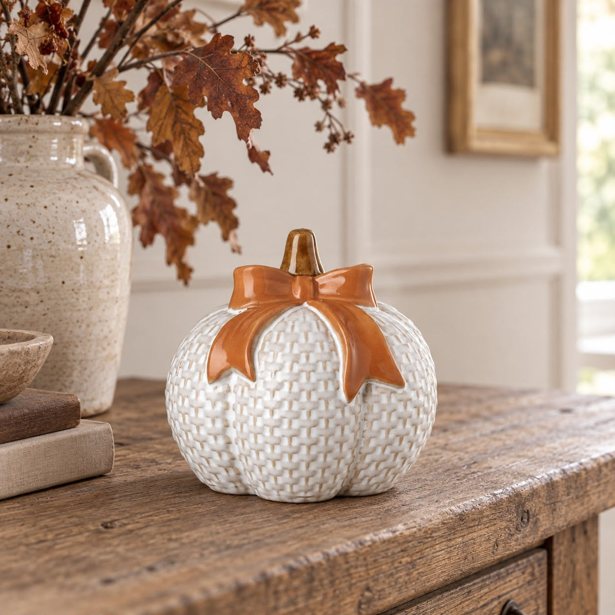 White ceramic pumpkin with orange bow, decorative autumn ornament from Heaven Sends, featuring a smooth finish and festive design.