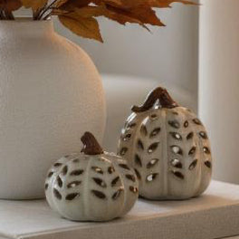 Neutral Ceramic Cut Out Light Up LED Tall Pumpkin, two pale pierced pumpkin lights beside an autumn vase
