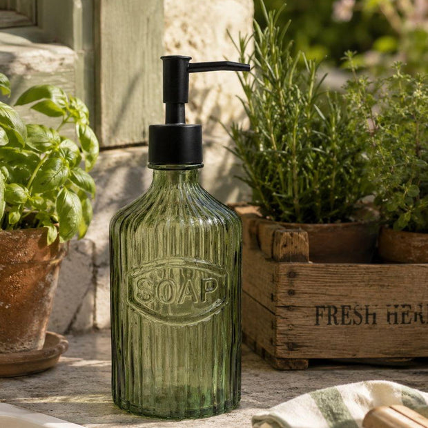 Green Glass Soap Dispenser With Black Pump, green ribbed glass soap bottle with black pump beside herbs
