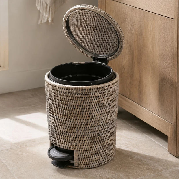 Wickham Rattan Round Pedal Waste Paper Bin, woven pedal bin with its lid open beside a bathroom cabinet
