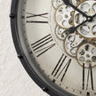 Black frame mechanical skeleton clock with visible gears and intricate design, showcasing a stylish and modern timepiece by Heaven Sends.