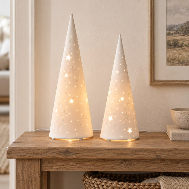 White Porcelain Christmas Tree Lamp, two glowing white cone tree lamps on a wooden console