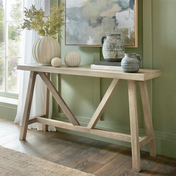Wooden console table from Hill Interiors' Haldon Collection, featuring a sleek design with a spacious top and sturdy legs.