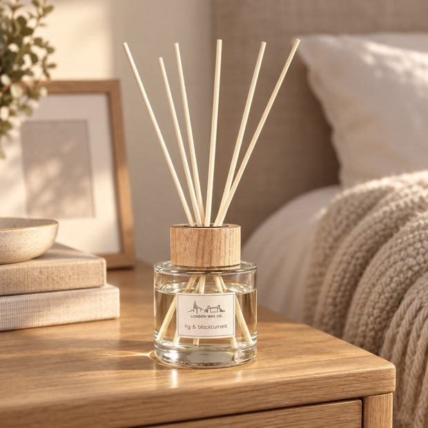 London Wax Company Reed Diffuser - Fig and Blackcurrant, reed diffuser on a coffee table beside a knitted throw