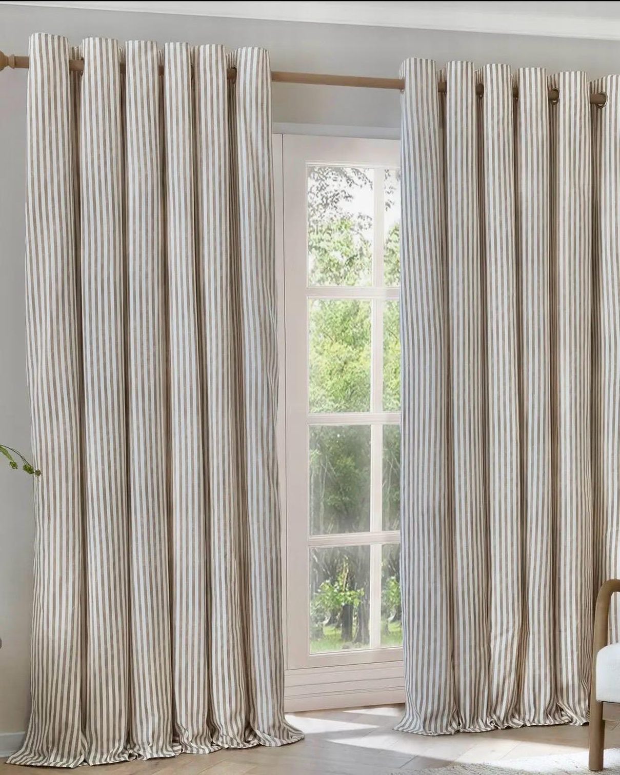Riva Home Yard Natural striped blackout eyelet curtains in black and white hanging in a living room window.