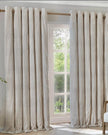 Riva Home Yard Natural striped blackout eyelet curtains in black and white hanging in a living room window.