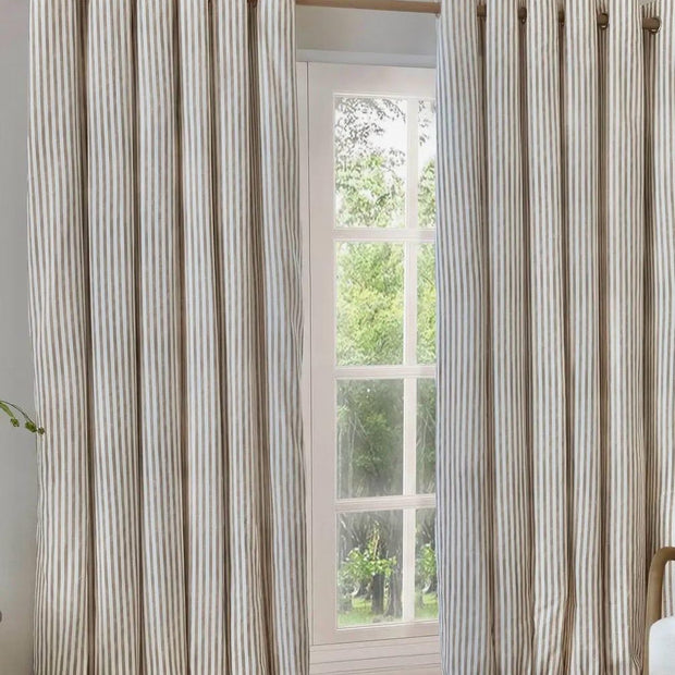 Riva Home Yard Natural striped blackout eyelet curtains in black and white hanging in a living room window.
