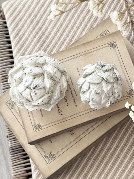 Stone Concrete Decorative Artichoke, two pale stone artichoke ornaments on stacked books