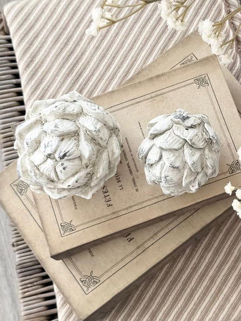 Stone Concrete Decorative Artichoke, two pale stone artichoke ornaments on stacked books