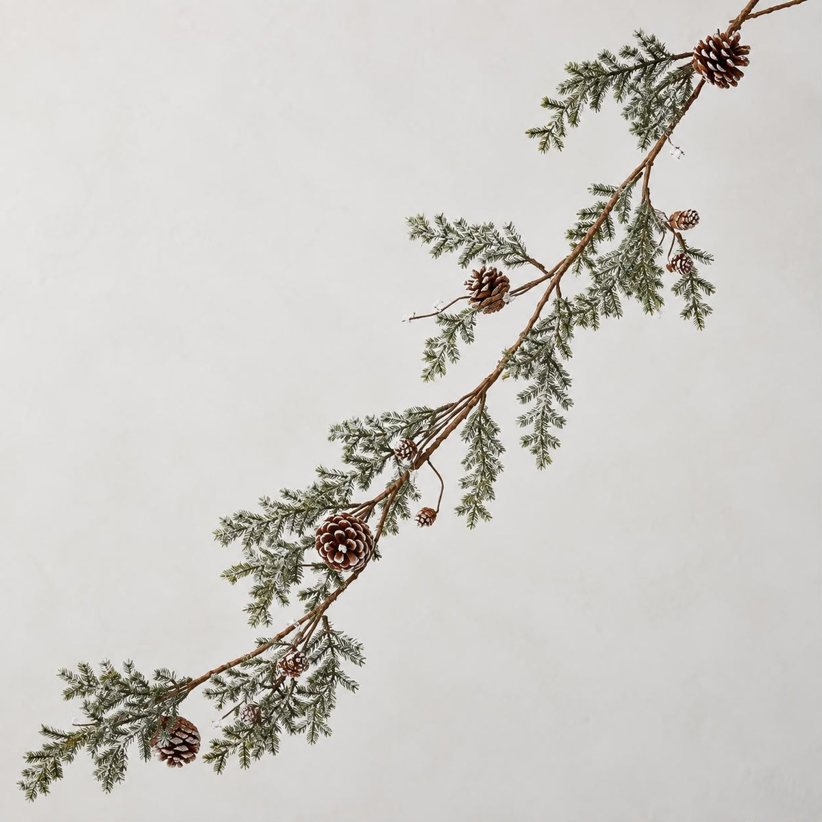 Pinecone garland detail against a neutral wall
