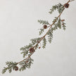 Pinecone garland detail against a neutral wall