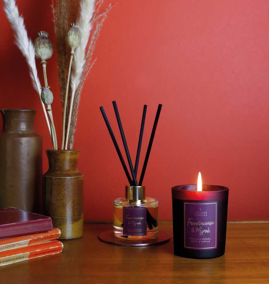 Shearer Candles Christmas jar candle with frankincense and myrrh scent, decorated with festive holiday design and a burning wick.