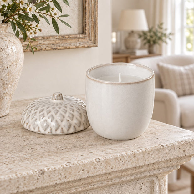 White Porcelain Acorn Candle Pot, white acorn candle pot with its textured lid beside it on stone