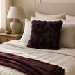 Burgundy Luxury Faux Fur Cushion, burgundy faux fur cushion on a bed with a matching throw