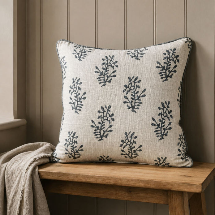 Grey Block Printed Reversible Flower Cushion Cover, cream reverse with grey sprigs on a wooden bench