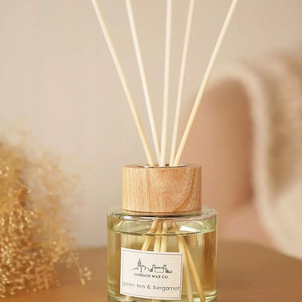 London Wax Company Reed Diffuser - Green Tea and Bergamot, close-up of the labelled diffuser bottle and pale reeds