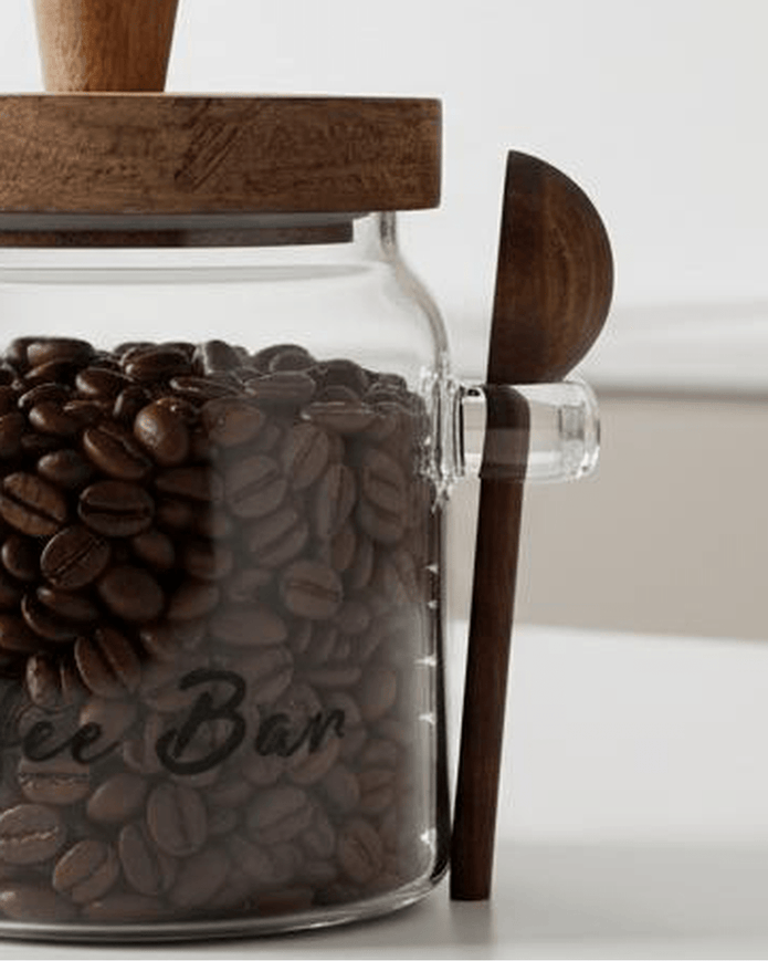 Glass coffee storage jar with dark wood lid and spoon, ideal for kitchen and dining, by Starlight Express.