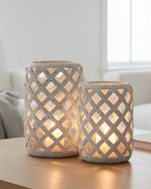 Stone Lattice Hurricane Lantern, two pale lattice lanterns glowing on a table