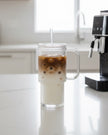 Glass ribbed Stanley-style iced coffee travel cup by Starlight Express, featuring a clear design with a lid for on-the-go drinking.