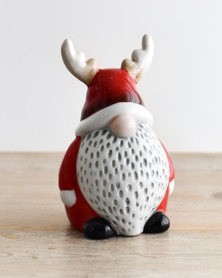 Decorative gnome figurine with reindeer antlers on a wooden surface