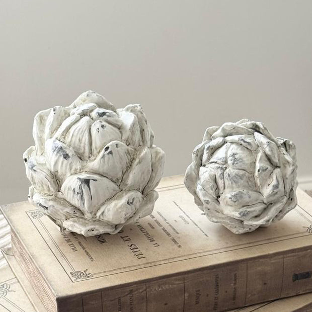 Stone Concrete Decorative Artichoke, two pale stone artichokes on stacked wooden books