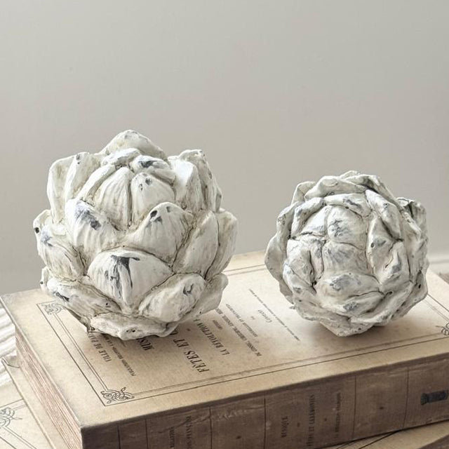Stone Concrete Decorative Artichoke, two pale stone artichokes on stacked wooden books
